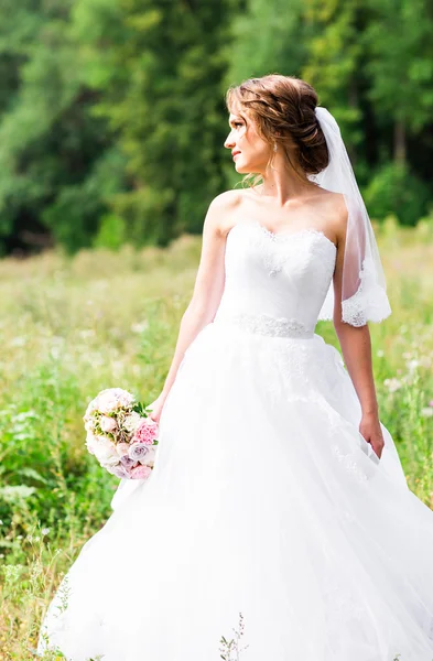 Menina noiva bonita em vestido de noiva e buquê de flores, ao ar livre retrato — Fotografia de Stock