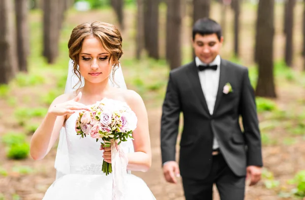 Novia y novio en un parque. Ramo de flores de boda nupcial —  Fotos de Stock