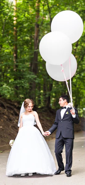 Sommarlovet, fest och bröllop koncept - par med färgglada ballonger — Stockfoto