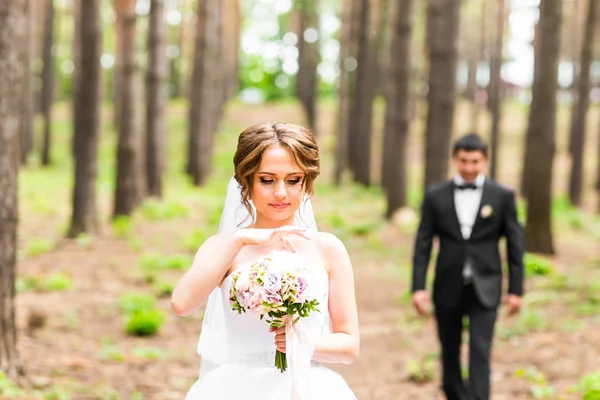 Sposo e sposa in un parco. Bouquet da sposa di fiori — Foto Stock