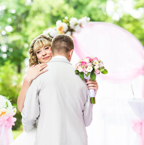 Happy newlywed romantic couple dancing at wedding aisle with pink decorations and flowers — Stock Photo, Image