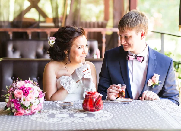 Gelukkige bruid en bruidegom samen in café plezier. Gelukkig jonggehuwde paar op bruiloft — Stockfoto