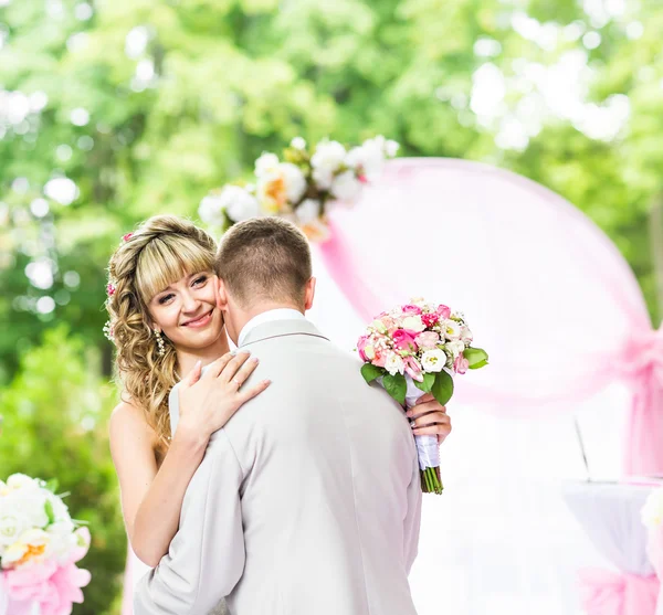 С новобрачной романтической парой, танцующей в свадебном проходе с розовыми украшениями и цветами — стоковое фото