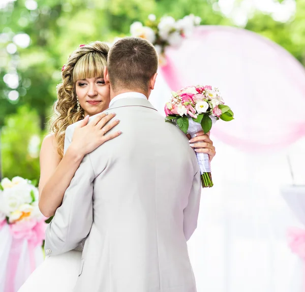 Happy newlywed romantic couple dancing at wedding aisle with pink decorations and flowers — Stock Photo, Image