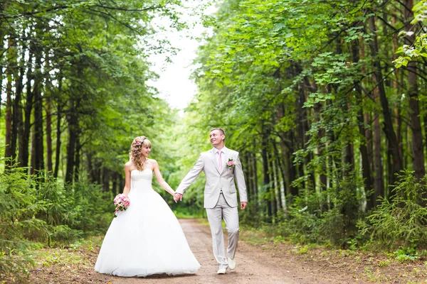 Jonge bruidspaar genieten van romantische momenten buiten op een zomer park — Stockfoto