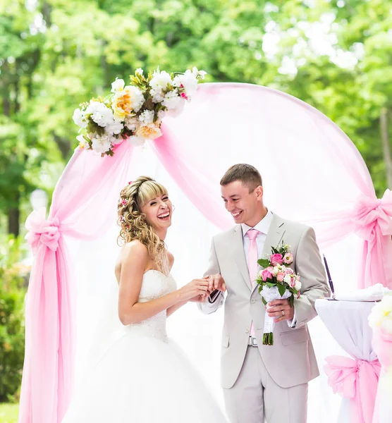 Novia feliz poniendo un anillo en los novios dedo durante la ceremonia de la boda —  Fotos de Stock