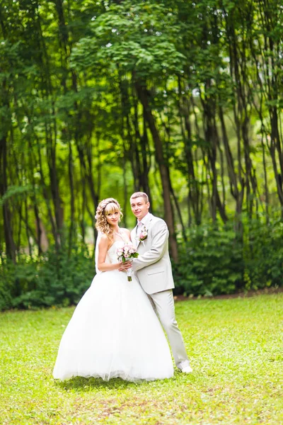 Unga bröllop par njuter av romantiska stunder utanför på en sommar park — Stockfoto