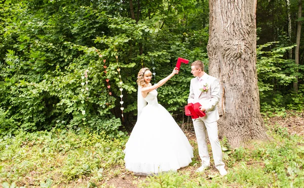 Retrato de casal recém-casado feliz lutando com letras decorativas — Fotografia de Stock