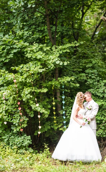 Молода весільна пара насолоджується романтичними моментами на вулиці на літньому парку — стокове фото