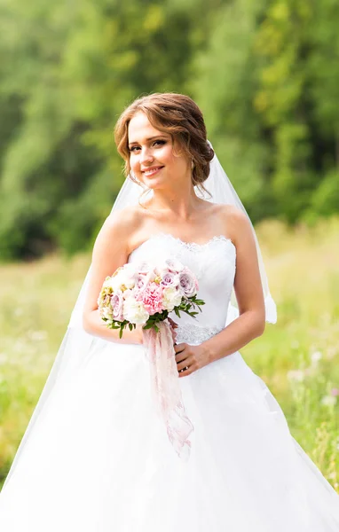 Schöne Braut mit Blumenstrauß im Freien — Stockfoto