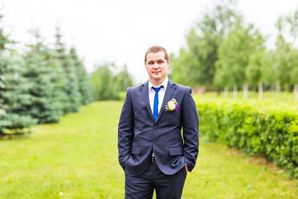 Bruidegom in pak op de natuur. Mannelijke portret buitenshuis. Knappe jongen buitenshuis — Stockfoto