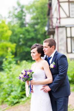 onu kucaklayan Düğün çifti, sarılma bir buket çiçek, holding gelin damat