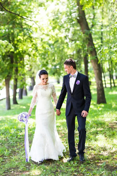 Noiva bonita feliz e noivo andando em um parque — Fotografia de Stock