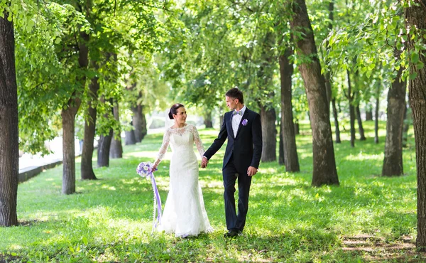 Noiva bonita feliz e noivo andando em um parque — Fotografia de Stock