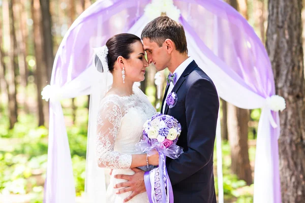 Braut und Bräutigam unter Torbogen — Stockfoto