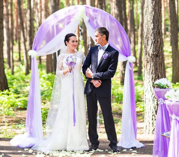 Nevěsta a ženich za svatební oblouk. — Stock fotografie