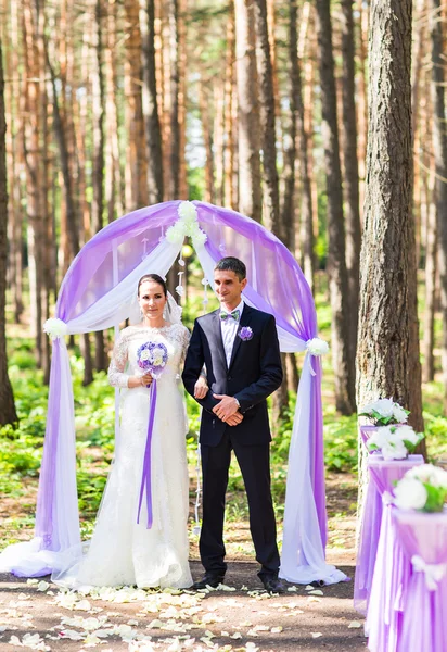 Menyasszony és a vőlegény az esküvő ív alapján. — Stock Fotó