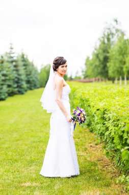 Güzel gelin kız gelinlik buket çiçek, açık havada portre ile