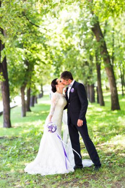 Zarif gelin ve damat açık havada düğün gününde öpüşme