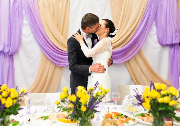 Noiva e noivo beijando na recepção do casamento — Fotografia de Stock