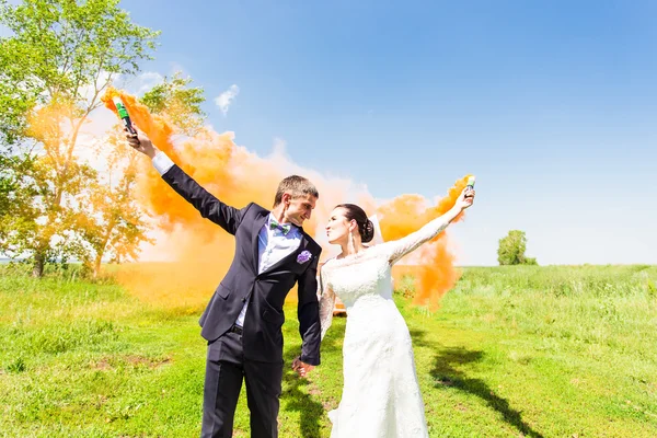 Pareja de boda con humo de color en el parque de verano —  Fotos de Stock