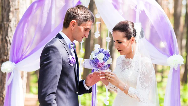 Невеста надевает обручальное кольцо на палец жениха. Свадебные церемонии — стоковое фото