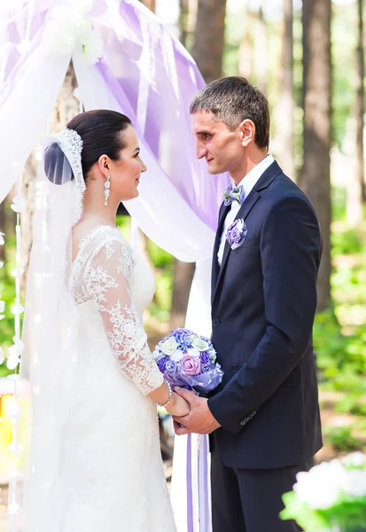 Mariée et marié sous l'arc de mariage — Photo