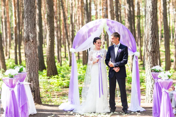 Nevěsta a ženich za svatební oblouk. — Stock fotografie