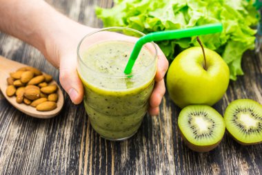 Kivi ve ahşap arka plan üzerinde elma ile sağlıklı yeşil smoothie