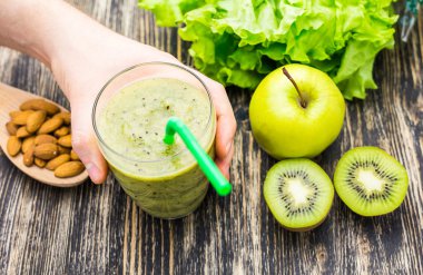 Kivi ve ahşap arka plan üzerinde elma ile sağlıklı yeşil smoothie