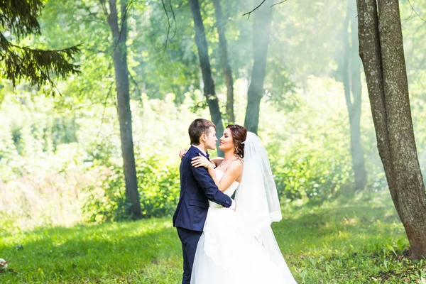 Νύφη και το γαμπρό στο γάμο ημέρα περπάτημα σε εξωτερικούς χώρους στη φύση την άνοιξη. — Φωτογραφία Αρχείου