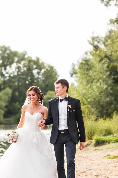 Couple de mariage marchant près du lac . — Photo