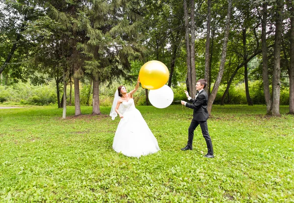 Жених и невеста с воздушными шарами на открытом воздухе — стоковое фото