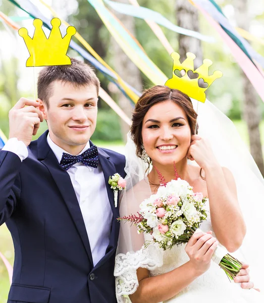Aprilscherz. Hochzeitspaar posiert mit Krone, Maske. — Stockfoto