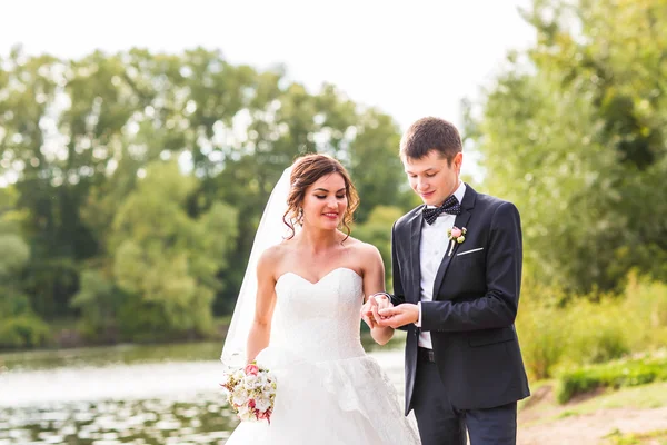 Hochzeitspaar steht am See. — Stockfoto