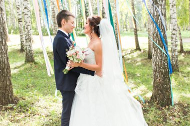 onu kucaklayan Düğün çifti, sarılma bir buket çiçek, holding gelin damat