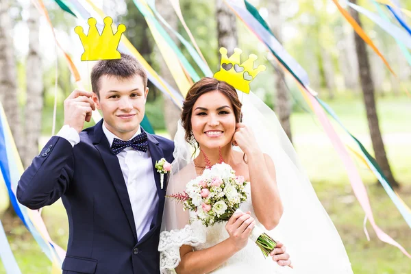 April Fools Day. Wedding couple posing with crown, mask.