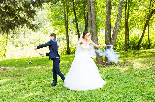 Hochzeit, Liebe, Beziehungen, Heirat. Lächelndes Brautpaar mit blauem Rauch — Stockfoto