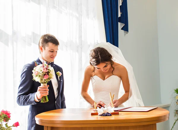 Wedding couple leaving their signatures — Stock Photo, Image