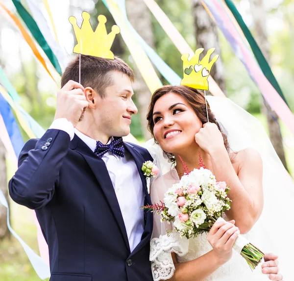 Aprilscherz. Hochzeitspaar posiert mit Krone, Maske. — Stockfoto