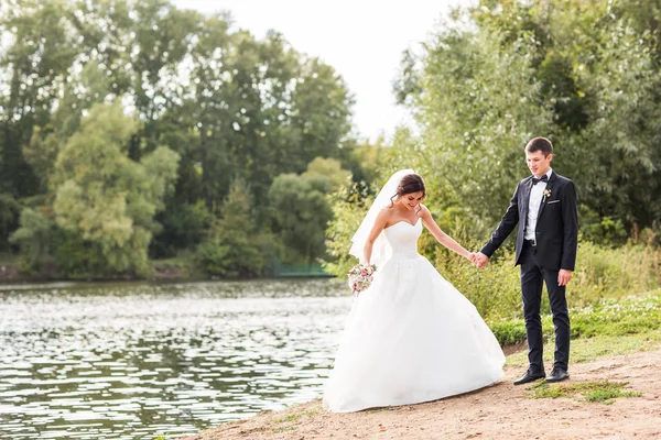 Casamento casal de pé perto do lago . — Fotografia de Stock