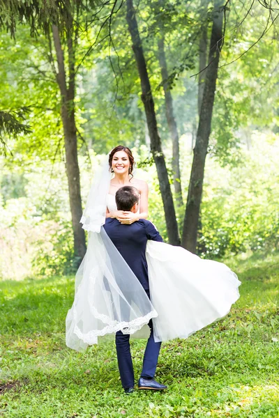 Menyasszony és a vőlegény az esküvő nap séta kint a tavaszi természet. — Stock Fotó