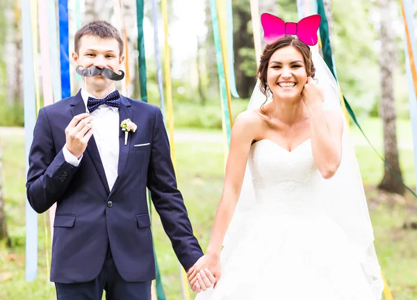 Aprilscherz. Hochzeitspaar posiert mit Maske. — Stockfoto