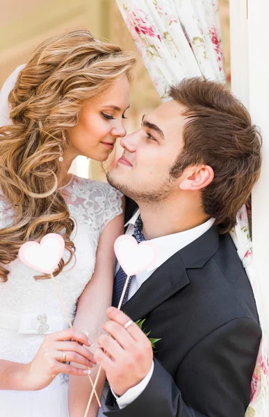 Ich liebe dich. Hochzeitspaar hält eine Karte in Herzform in der Hand. sie stehen und lächeln. — Stockfoto