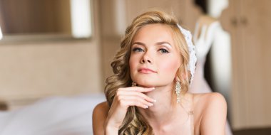 Güzel genç gelin düğün makyaj ve saç yatak ile çekici yeni evli kadın var düğün için son hazırlık ve sunuş.