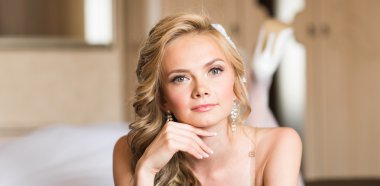 Güzel genç gelin düğün makyaj ve saç yatak ile çekici yeni evli kadın var düğün için son hazırlık ve sunuş.