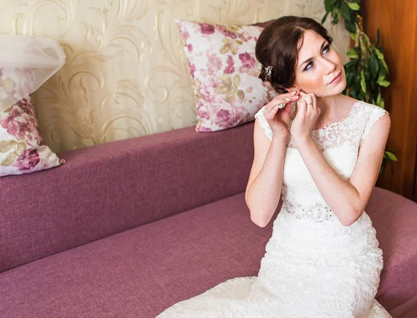 Elegante Braut setzt Ohrringe Nahaufnahme, Vorbereitungen für die Hochzeit — Stockfoto