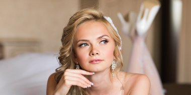 Güzel genç gelin düğün makyaj ve saç yatak ile çekici yeni evli kadın var düğün için son hazırlık ve sunuş.