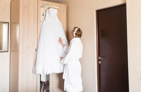 The bride in white bathrobe. Wedding preparations.