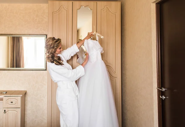 Die Braut im weißen Bademantel. Hochzeitsvorbereitungen. — Stockfoto